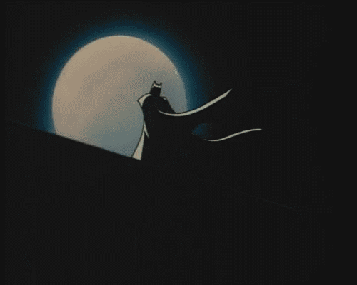 batman standing in front of the moon
